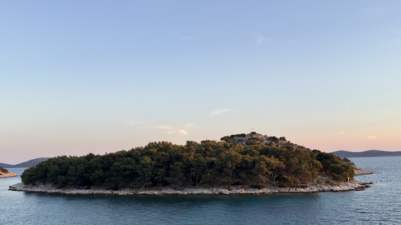 Tree-covered island near Tribunj at dusk